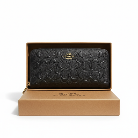 Professional studio image of a black Coach signature long wallet in a presentation box