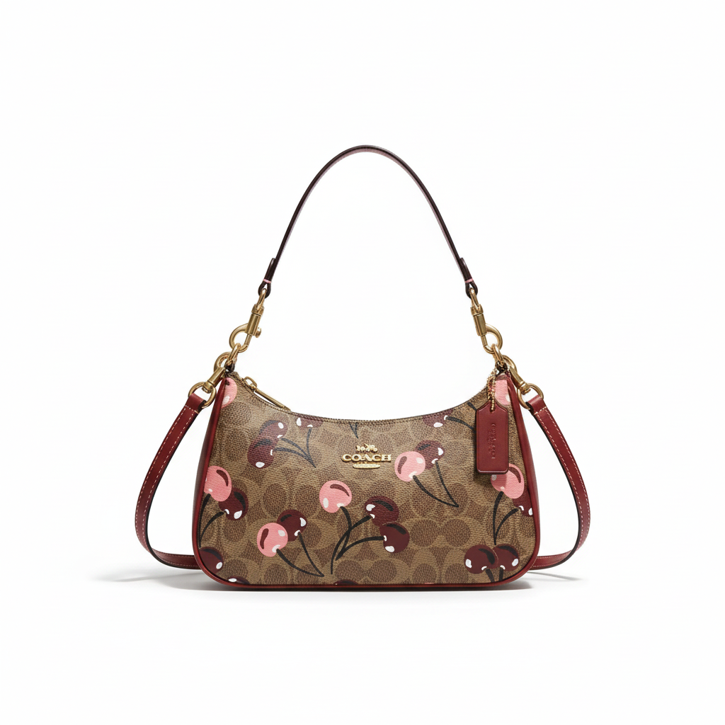Professional studio image of a Coach signature shoulder bag with pink cherry print and burgundy straps
