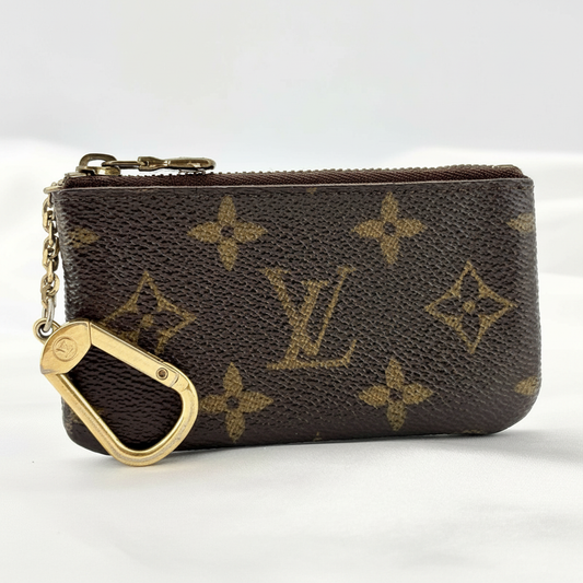 Professional studio image of a brown Louis Vuitton monogram zip key pouch with gold carabiner